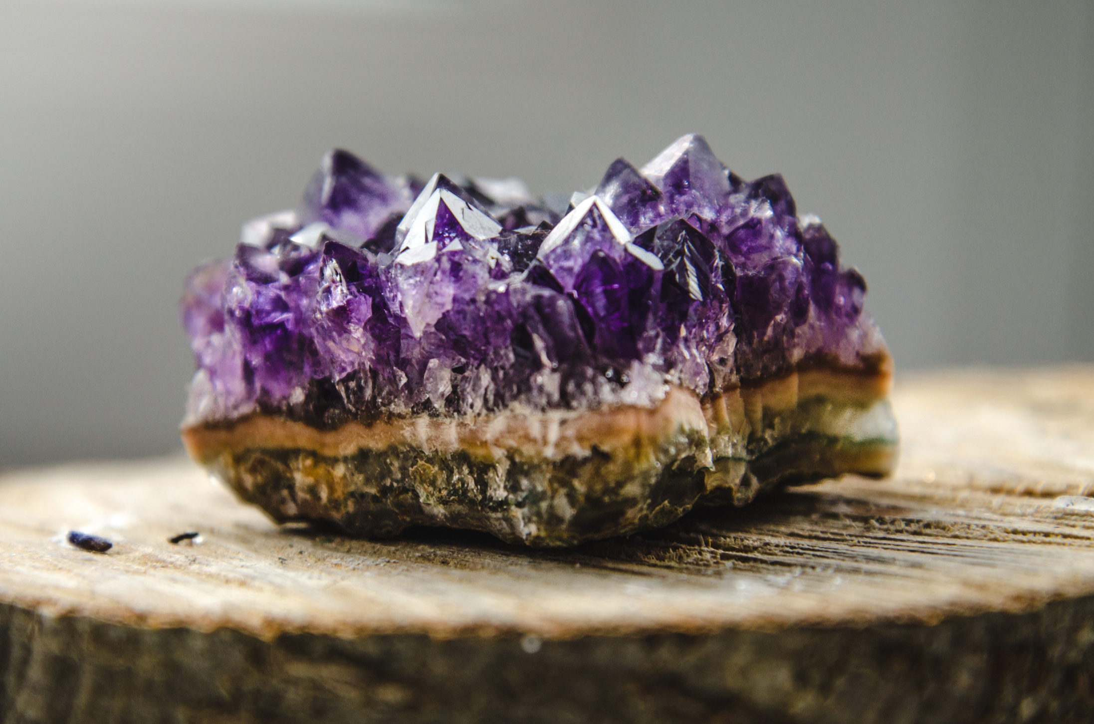 Raw amethyst rock with reflection on natural wood crystal ametist